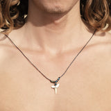 Surfer with a real shark tooth necklace  on, featuring a fossil shark tooth as the central pendant, surrounded by glass seed beads on a black cord
